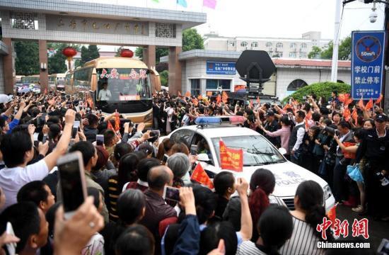 6月5日上午,安徽毛坦厂中学考生出发,万余民众冒雨相送。8时08分,28辆大巴车从毛坦厂校园缓缓开出,毛坦厂镇过万民众夹道欢送。 中新社记者 韩苏原 摄