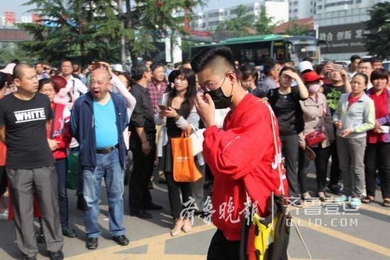 这位戴口罩的帅哥穿了一件宽松的红色外套