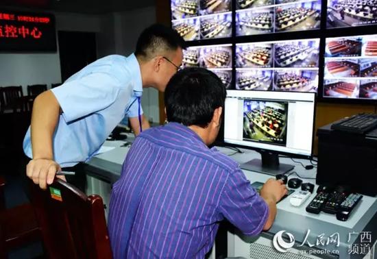 每个评卷室都设有视频监控。图为监控中心的工作人员在查看视频监控。(赵洋君 摄)