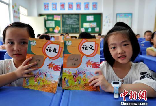 资料图:小学新生展示语文教材。张斌 摄