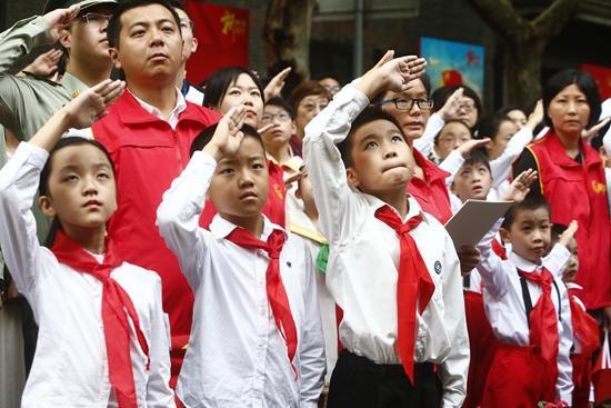 10月1日,国庆与五星红旗更配哦,国庆节当天,少先队员敬礼瞩目五星红旗徐徐升起。《青年报》吴恺/摄