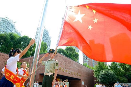 武警官兵为你护旗。在上海市虹口区中共四大纪念馆广场(后称“国旗广场”),少先队员升旗手与武警官兵共同升旗。