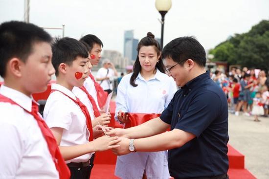 8月13日,少先队员手里接过团上海市委书记王宇颁发的纪念证书,脸上贴着小国旗,小同学们心里美滋滋。