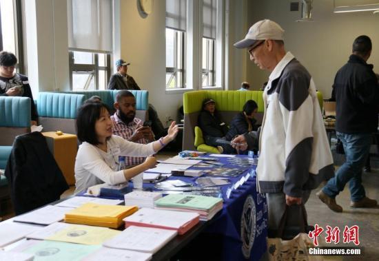 资料图:美国移民局官员正在为公民提供入籍服务。中新社记者 刘丹 摄