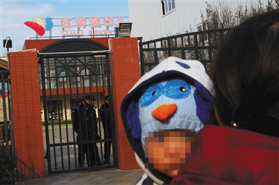 11月22日,家长报警称,红黄蓝幼儿园新天地分园虐童。23日,幼儿园大门紧闭,一附近居民带着孩子来查看。新京报记者 王嘉宁 摄