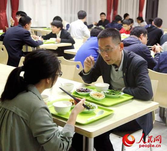 施一公在餐厅里边吃饭边指导学生。赵永新摄