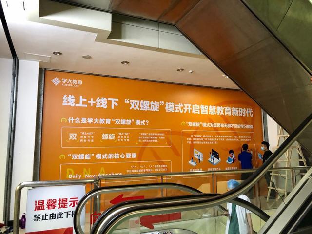 学大教育正在张贴宣传海报,突出线上线下“双螺旋”模式