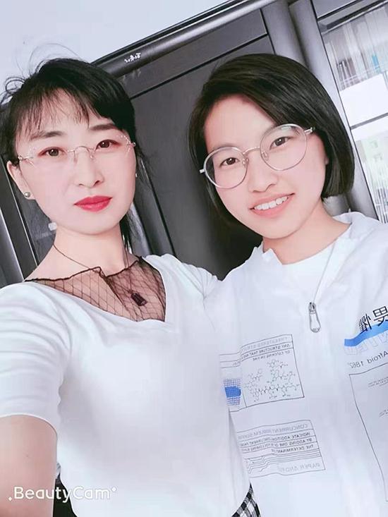 石甄(右)和高中语文老师合影。受访者供图