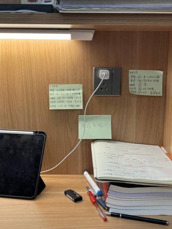 林子方在沉浸自习室的书桌一角,墙壁上贴着学习目标和给自己鼓劲的便签条