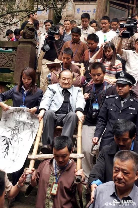 2004年,金庸坐滑竿游青城山。 微博@成都商报客户端 资料图