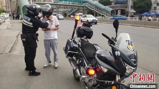 7日晨,乌鲁木齐一名参加高考的学生,因为走错考场,民警屈颖超立即发动摩托车送学生去另外一考点。 李小艺 摄