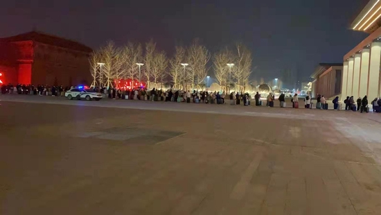 2021年12月27日晚10时许,西安火车站站前广场,滞留考生排起队伍登记信息。受访者供图