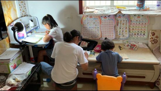 6月11日,陈春秀在家辅导孩子做作业。新京报记者王瑞文摄