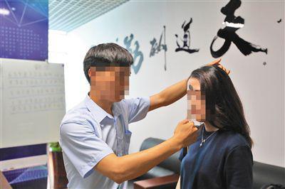 6月19日,北京双优贝贝公司,记者体验额头吸附硬币。专家表示,此种现象仅因为摩擦力产生,没有所谓磁场一说。 新京报记者 王飞 摄