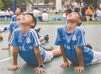 海珠区江南新村第二小学的学生在足球训练前热身。