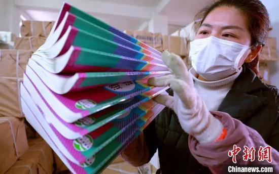 资料图:江西省吉安市泰和县新华书店工作人员在分拣清点新教材。 司马天民 摄
