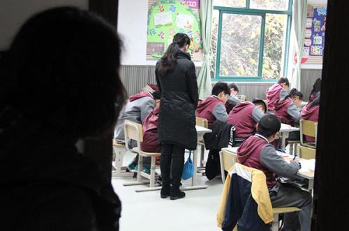 亨亨妈妈(左一)在教室外看着自己的儿子,班主任曹彬彬站在亨亨右边。