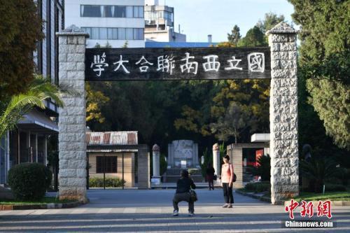 资料图:2017年11月1日,游客在西南联大旧址前留影。当日,正值西南联合大学建校80周年纪念日。中新社记者 任东 摄