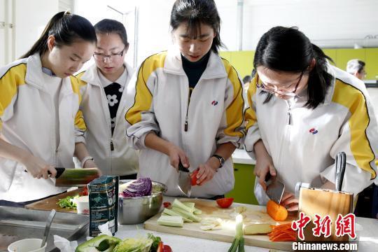 图为青海师范大学附属中学厨艺课,几位同学正在切蔬菜。 张海雯 摄