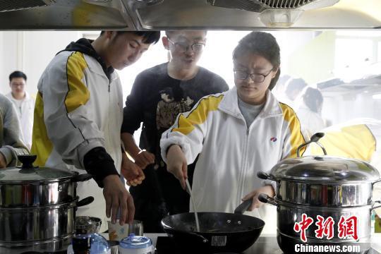 图为青海师范大学附属中学厨艺课,几位同学正在尝试炒菜。 张海雯 摄
