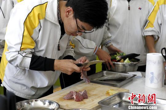 图为青海师范大学附属中学厨艺课,一位同学正在跟牛肉“较劲”。 张海雯 摄