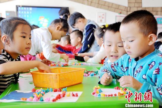 资料图:甘肃张掖民乐县第一幼儿园大班的小朋友为老师制作爱心卡片(图文无关)。 张渊 摄