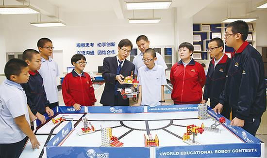 李永军老师在机器人社团活动室为社团学生讲解能力风暴机器人。