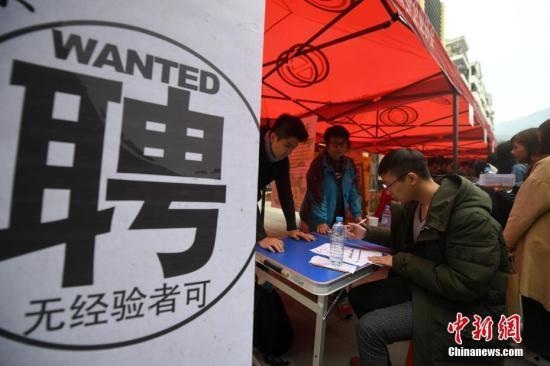资料图:求职者在招聘会现场了解招聘信息。 张斌 摄