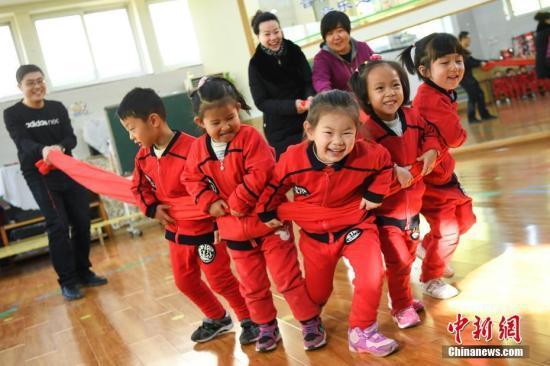 资料图:幼儿园内,老师、家长们与孩子们互动游戏。 武俊杰 摄