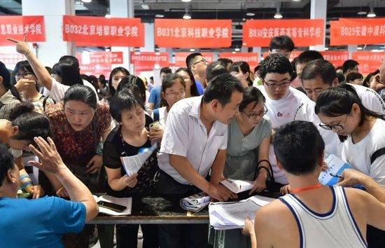 ▲资料图:家长和考生在高考考生职业生涯指导与志愿填报咨询会上了解高校招生政策信息。图/新华社