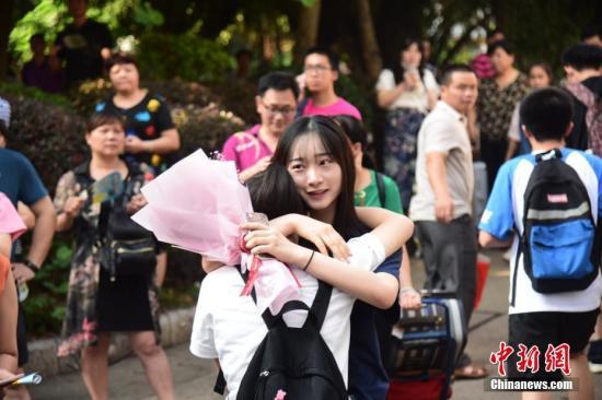 资料图:一名家属拥抱走出高考考场的考生。 王以照 摄