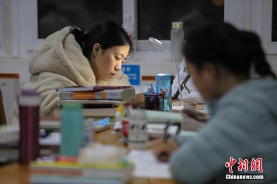 11月25日,贵州民族大学逸夫图书馆内,考研学生正在看书复习,为2020年全国硕士研究生招生考试做准备。 中新社记者 瞿宏伦 摄