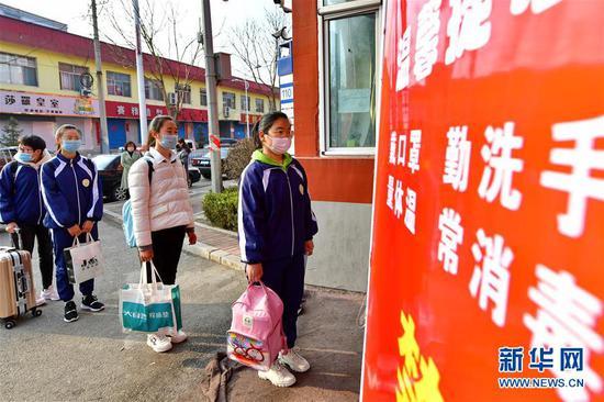 李彦昀(右一)在山西省静乐县第一中学门口排队进入学校(3月25日摄)。 新华社记者 曹阳 摄
