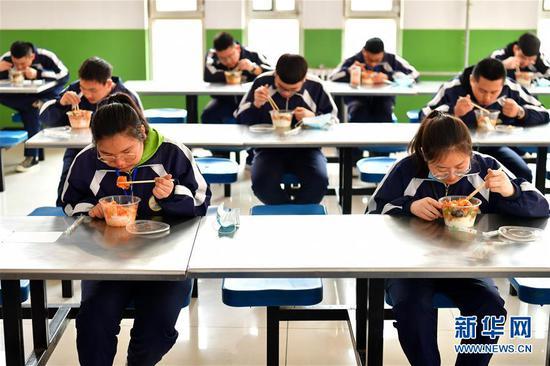 李彦昀(前左)在山西省静乐县第一中学食堂吃饭(3月25日摄)。 新华社记者 曹阳 摄
