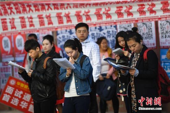 资料图:参加公务员考试的考生走进考点。 韦亮 摄