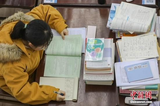 图为一位考研学生在南昌大学图书馆的自习室内复习备考。 刘力鑫 摄