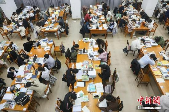图为众多考研学生在南昌大学图书馆的自习室内复习备考。 刘力鑫 摄