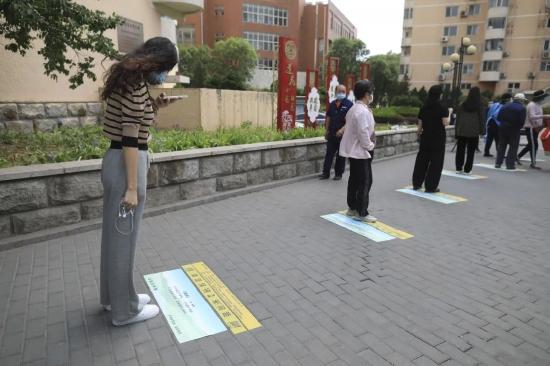 ▲5月5日,海淀区羊坊店街道莲花小区,一位女士在排队时拍摄地上的古诗。 新京报记者 浦峰 摄