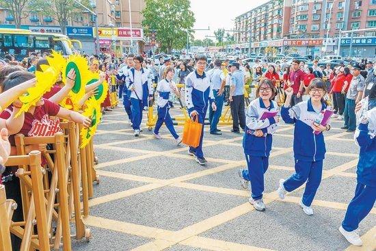 6月7日,潞河中学考点,送考老师手拿“向日葵”为考生加油。