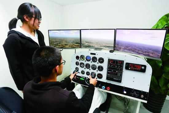 学生体验模拟飞行技术。 摄/本报记者 云凯杰