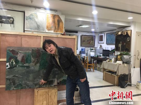 图为西北民族大学美术学院教授刘志刚展示自己的漆画作品《丝路古风》。 崔琳 摄