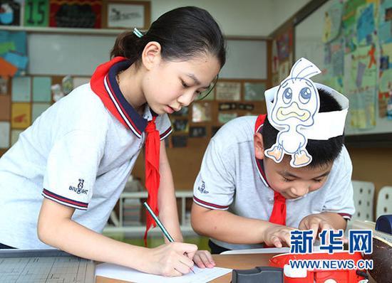 9月3日,上海市天山第一小学的学生放学后在“创意实验室”编写英文情景剧剧本。