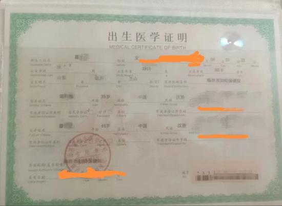 ▲钟女士展示其自称为他人非法代办的新生儿出生证