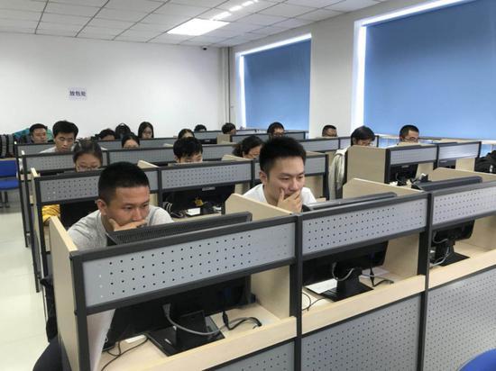 图为2018年国家统一法律职业资格考试北京市西城区经济科技大学考点现场,考生们在用计算机进行答题。