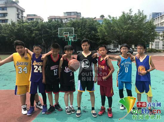 廖靖(左五)在与孩子们打篮球。