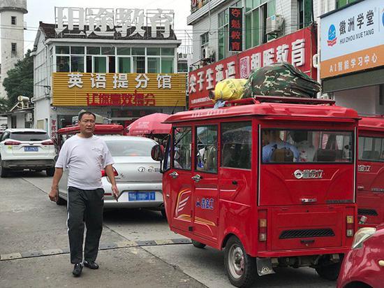 离校日,家长和学生一起乘车赶往公交车站。