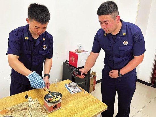消防员正在用炒锅炒菜。 本版摄影/新京报记者 彭镜陶