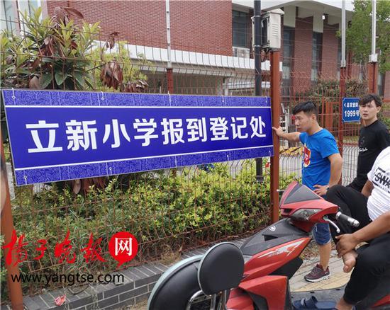 勤惜小学北门处挂出的“立新小学报到登记处”牌子,家长们在此焦急守候
