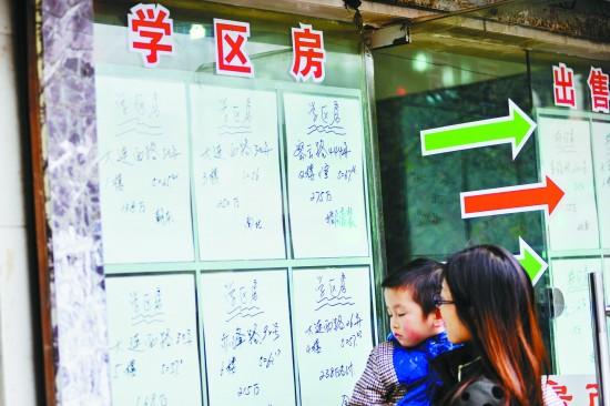 2015年3月18日,上海,一位家长带着孩子在中介门口看“学区房”房源CFP供图(资料图片)