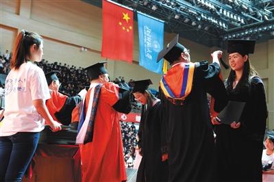 25日,毕业典礼上,北师大的老师为获得学士学位的本科毕业生拨穗。新京报记者 吴江 摄